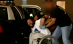 San Diego police force a man out of his wheelchair and into the back of a police car.